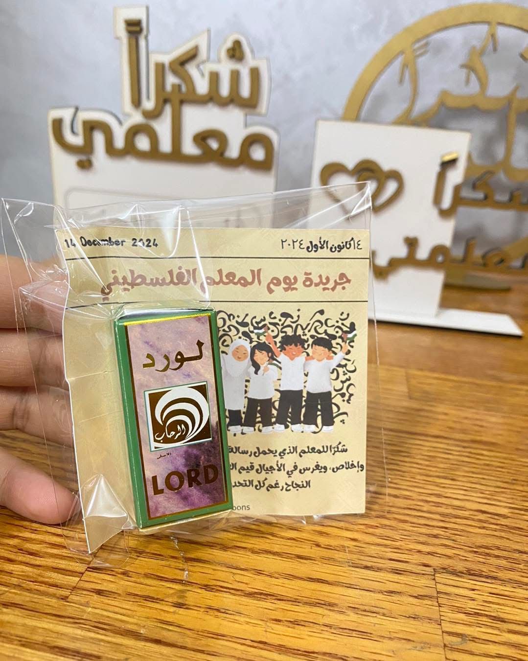 عطر صغير مغلف مع بطاقة للمعلم